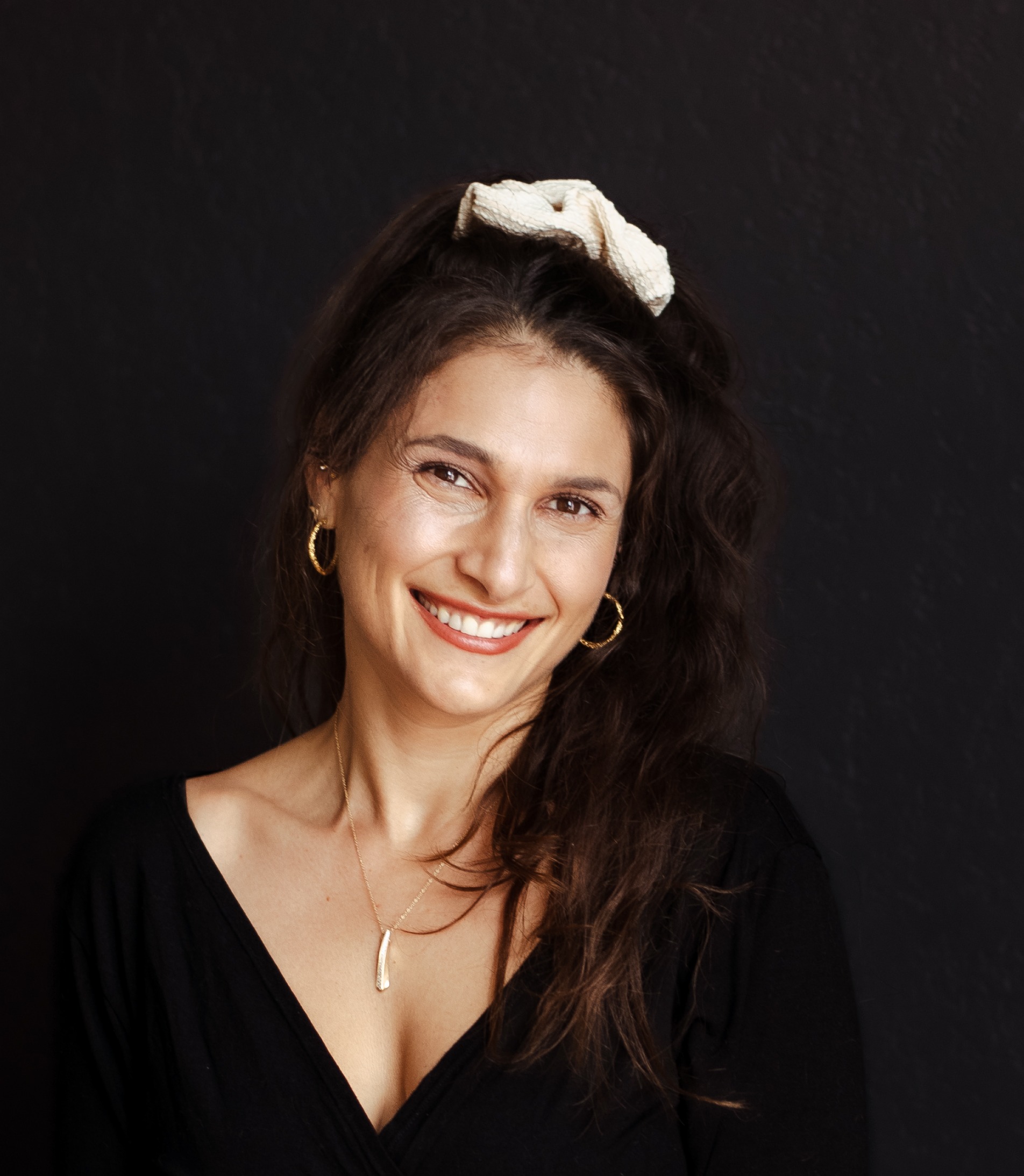 Amira Attar smiling, wearing a cream headband